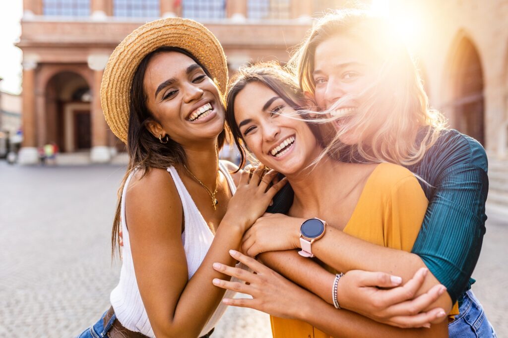 Happy group of beautiful young women laughing together outdoors